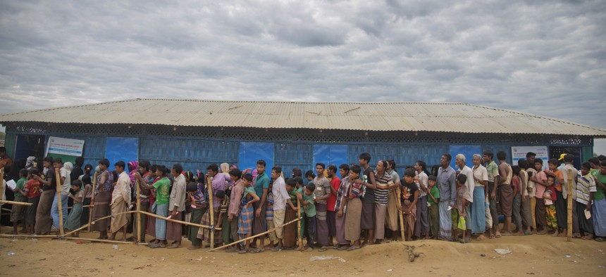 Rohingya Muslims, who crossed over from Myanmar into Bangladesh, wait in queues to receive aid at Kutupalong refugee camp in Ukhiya, Bangladesh, Wednesday, Nov. 15, 2017.