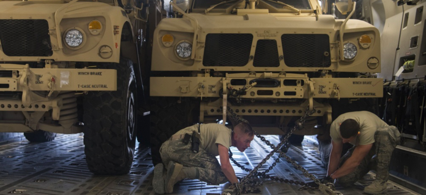 Tech. Sergeants Josiah Bourke and Nick Akins, 332nd Expeditionary Logistics Readiness Squadron air transportation specialists, secure mine-resistant ambush protected vehicles for transportation in Southwest Asia March 7, 2018.
