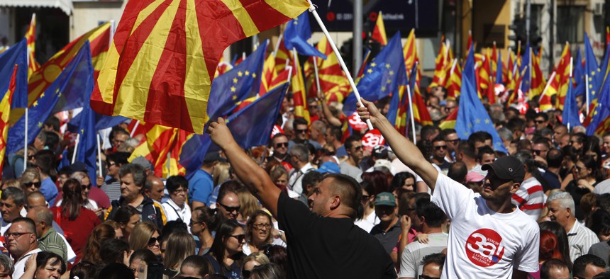 People waving Macedonian and EU flags take part in a march named "For European Macedonia", through a street in Skopje, Macedonia, Sunday, Sept. 16, 2018.