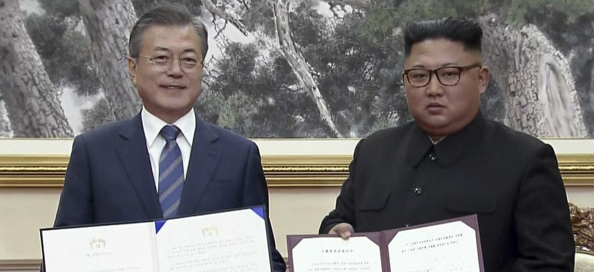 In this image made from video, South Korean President Moon Jae-in, left, and North Korean leader Kim Jong Un pose after signing documents in Pyongyang, North Korea Wednesday, Sept. 19, 2018.