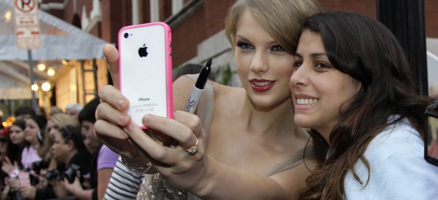 Country music star Taylor Swift helps Mariana Gomes, right, of Brazil, by taking a souvenir photo of them with Gomes' phone as Swift arrives for the Academy of Country Music Honors show on Monday, Sept. 19, 2011, in Nashville, Tenn.