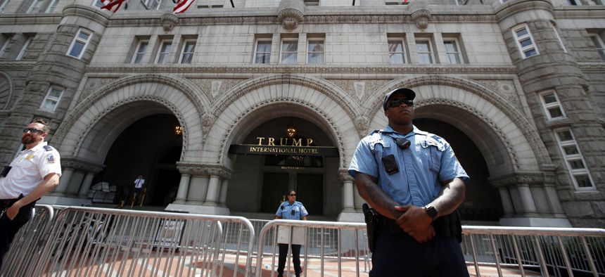Law enforcement officers stand guard in front of the Trump Hotel during a march to protest the Trump administration's approach to illegal border crossings and separation of children from immigrant parents, Saturday, June 30, 2018, in Washington.