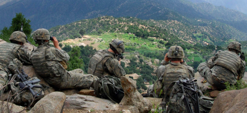 Soldiers from 2nd Battalion, 503rd Infantry Regiment, provide security during Operation Destined Strike while Soldiers below search a village in the Chowkay Valley in Kunar Province, Afghanistan.