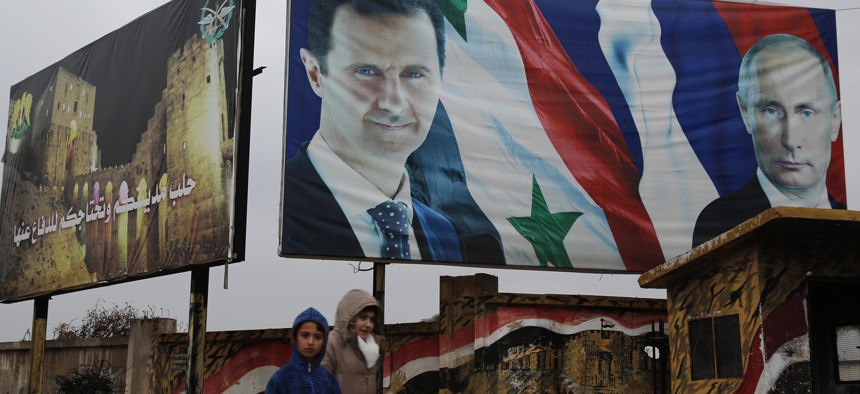 yrian walk by posters of Syrian President Bashar Assad and Russian President Vladimir Putin in Aleppo, Syria, Thursday, Jan. 18, 2018. 
