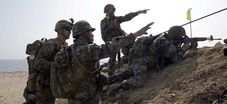 U.S. Marine, left, talks with South Korean Marines during the U.S.-South Korea joint landing military exercises south of Seoul, South Korea, Monday, March 30, 2015.