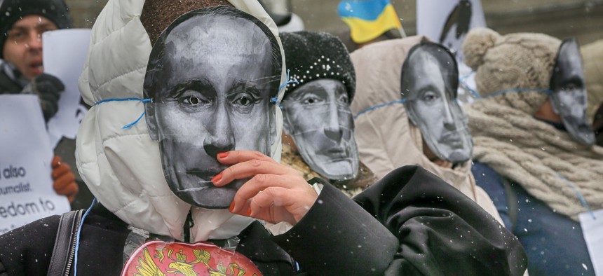Colleagues of jailed journalist Roman Sushchenko wear masks depicting Russian President Vladimir Putin during a protest in front of the Russian Embassy demanding his release in Kiev, Ukraine, Wednesday, Nov. 2, 2016. 