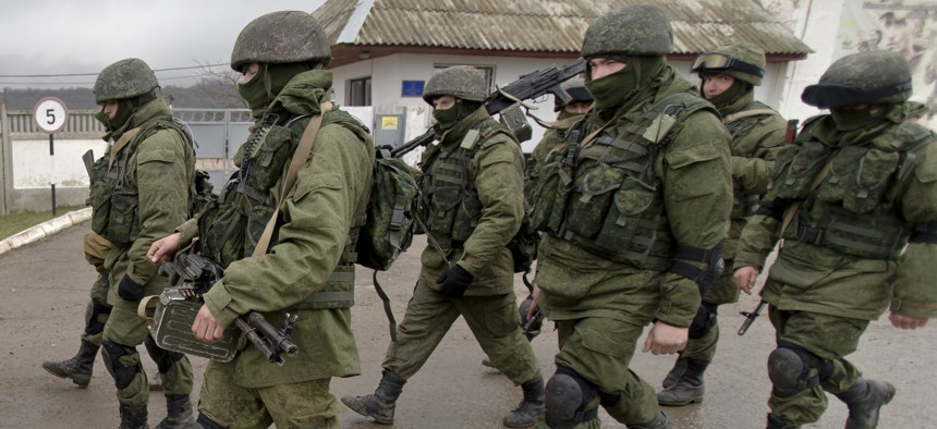In this March 20, 2014 file photo Pro-Russian soldiers march outside an Ukrainian military base in Perevalne, Crimea.
