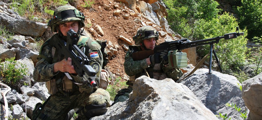 Two Croatian soldiers from 1st Platoon, 1st Company, Tiger Battalion, take cover and provide security as their platoon conducts a movement to contact exercise during the Immediate Response 2012 (IR12) training event held in Croatia on May 29, 2012.