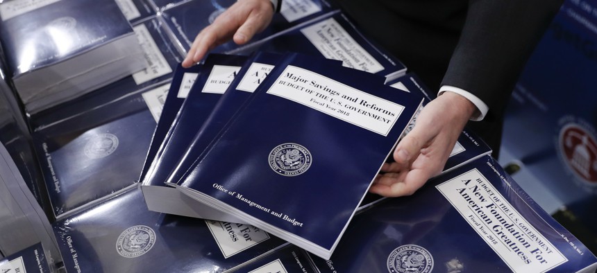 Eric Ueland, Republican staff director, Senate Budget Committee, lays out a copy of President Donald Trump's fiscal 2018 federal budget, before distributing them to congressional staffers, Tuesday, May 23, 2017, on Capitol Hill in Washington.