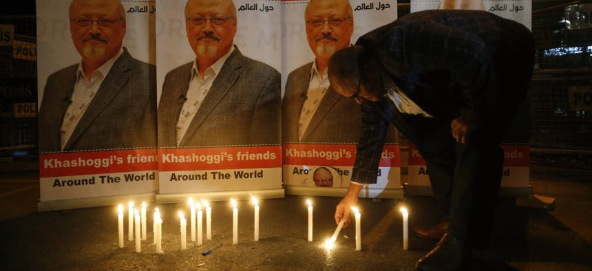 An activist lights a candle during a candlelight vigil for Saudi journalist Jamal Khashoggi outside Saudi Arabia's consulate in Istanbul, Thursday, Oct. 25, 2018.