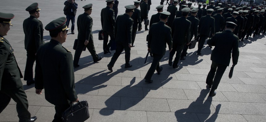 In this photo taken Wednesday, March 8, 2017, Chinese military officers file into near the Great Hall of the People where a plenary session of the National People's Congress is held in Beijing, China.