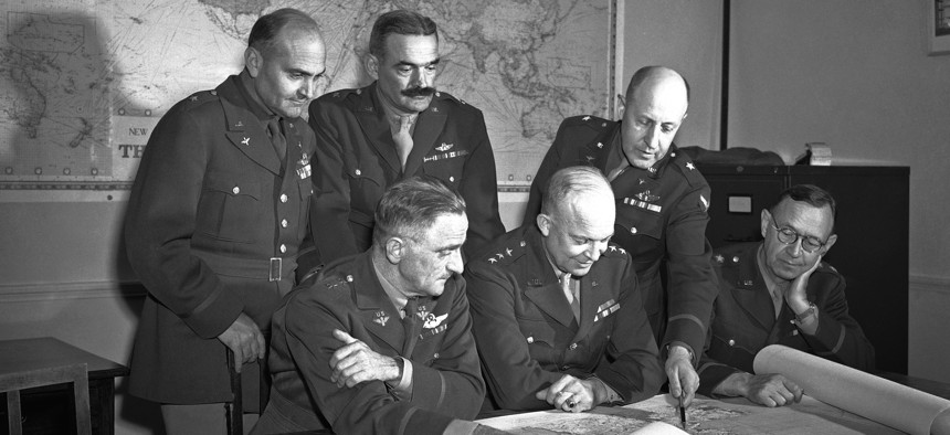 These six U.S. generals, who are directing the operations of U.S. forces from Great Britain check over a map during a conference on August 19, 1942. 