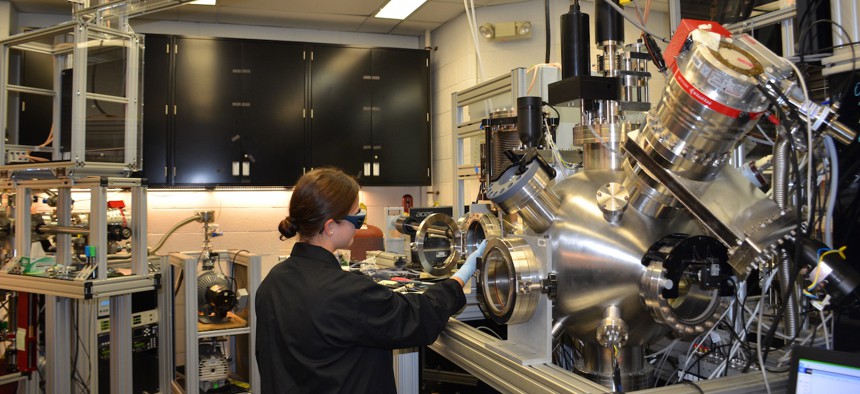 Ashley Wissel, Purdue University undergraduate student, works with the pulsed laser deposition chamber in the Materials and Manufacturing Directorate. This is used to study growth of thin layers of material at low temperatures.