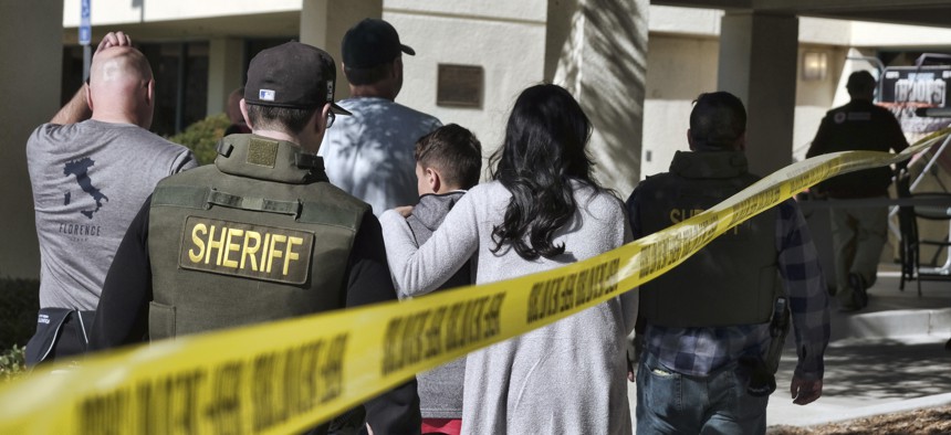 Family members are led into the Thousand Oaks Teen Center where families have gathered after a deadly shooting at a bar on Thursday, Nov. 8,2018, in Thousand Oaks, Calif.