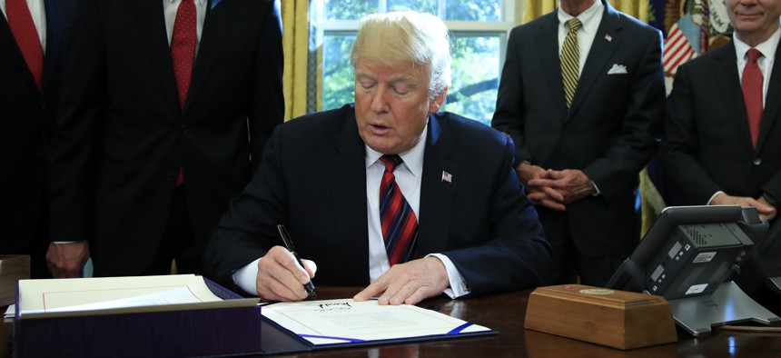 President Donald Trump signs the “America’s Water Infrastructure Act of 2018” into law during a ceremony in the Oval Office at the White House in Washington, Tuesday, Oct. 23, 2018. 