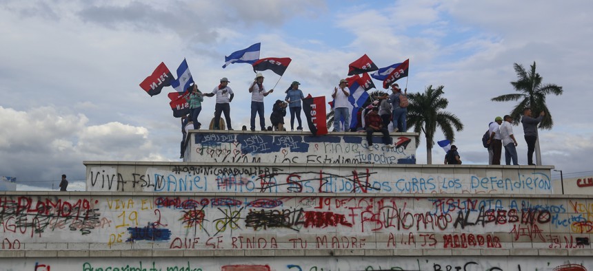 Government supporters wave Sandinista flags on top of the Metro Center roundabout during a pro-government march in Managua, Nicaragua, Wednesday, Sept. 26, 2018.