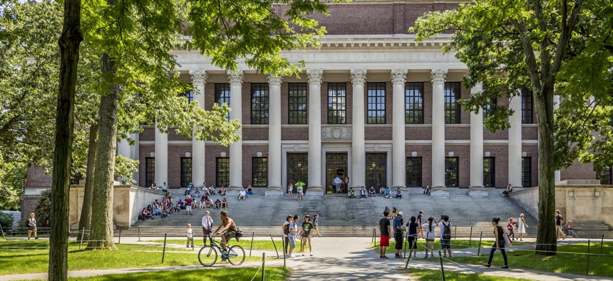 Panorama of the Harvard University's campus in Cambridge, MA, USA showcasing its historic architecture, gardens and students passing by on June 2, 2014.