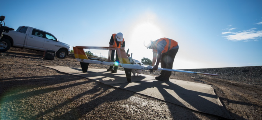 Brett Dokken and Stephen Marshall, unmanned aerial vehicle pilot contractors, prepare a civilian drone for takeoff at Melrose, New Mexico, Aug. 17, 2018.