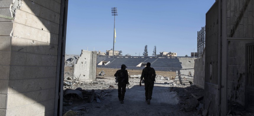 Members of the U.S.-backed Syrian Democratic Forces (SDF) enter the stadium that was the site of Islamic State fighters' last stand in the city of Raqqa, Syria, Wednesday, Oct. 18, 2017.
