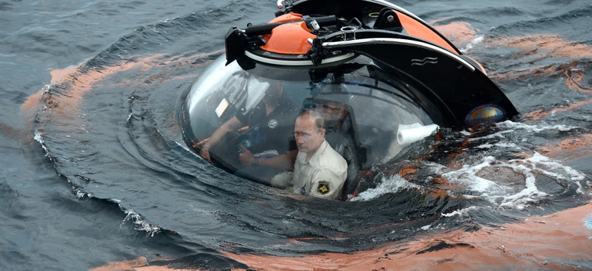 Russian President Vladimir Putin, center, sits on board a bathyscaphe as it plunges into the Black Sea along the coast of Sevastopol, Crimea, Tuesday, Aug. 18, 2015.
