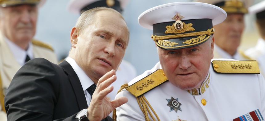 Russian President Vladimir Putin, left, chats with Commander-in-Chief of the Russian Navy Admiral Vladimir Korolev as they attend the military parade during the Navy Day celebration in St.Petersburg, Russia, on Sunday, July 30, 2017. 