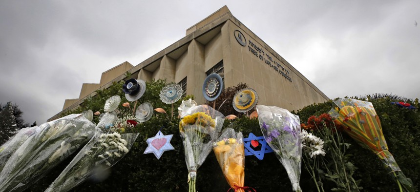 In this Tuesday, Nov. 20, 2018 photo, a makeshift memorial of flowers rests on bushes outside the Tree of Life Synagogue in Pittsburgh.