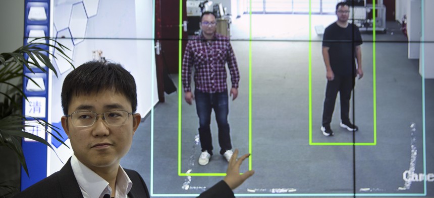 In this Oct. 31, 2018, photo, Huang Yongzhen, CEO of Watrix, demonstrates the use of his firm's gait recognition software at his company's offices in Beijing.