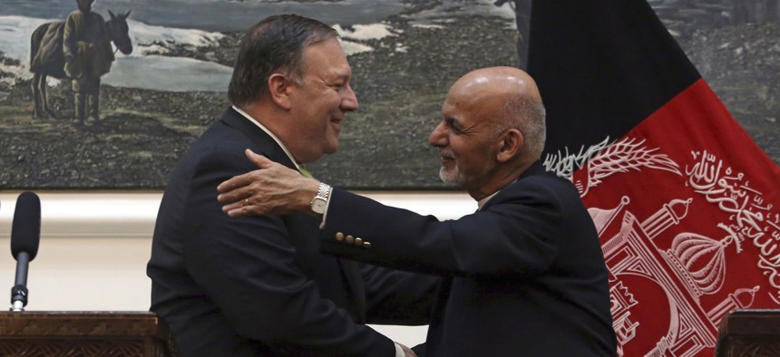U.S. Secretary of State Mike Pompeo, left and Afghan President Ashraf Ghani, shake hands after a press conference at the presidential palace in Kabul, Afghanistan, Monday, July 9, 2018.