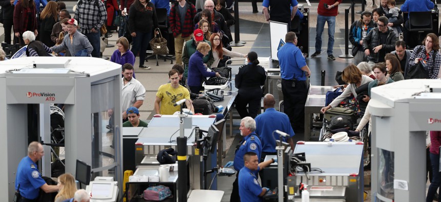 Travelers wait in long lines to pass through a security checkpoint in Denver International Airport Wednesday, Nov. 21, 2018, in Denver. 