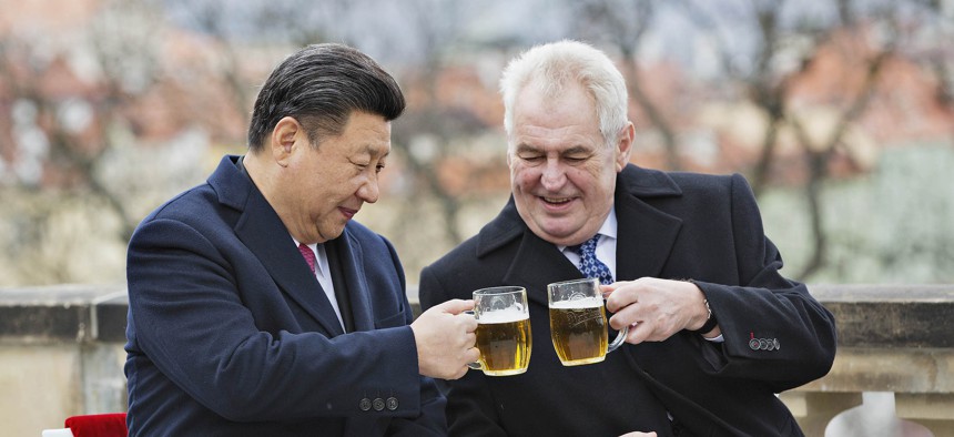 Chinese President Xi Jinping, left, and Czech Republic's President Milos Zeman, right, clink glasses of beer on the terrace of the Strahov Monastery in Prague, Czech Republic, Wednesday, March 30, 2016.