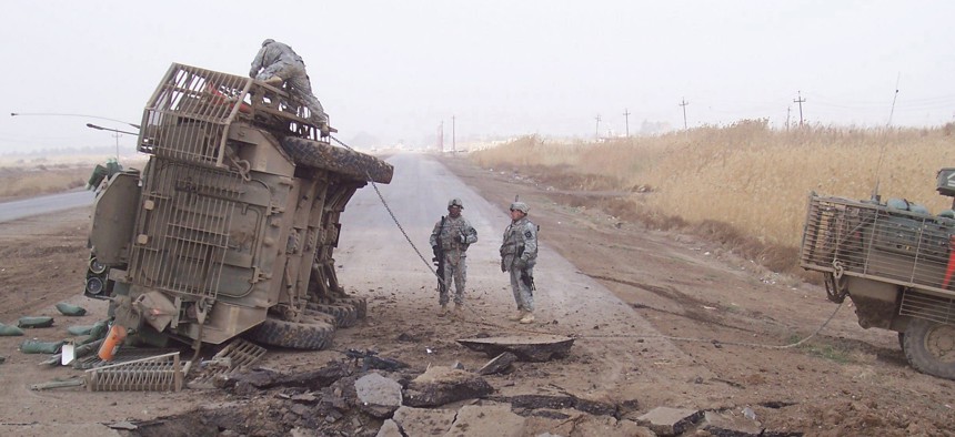 A Stryker fighting vehicle lies on its side after surviving a buried IED blast in 2007. 
