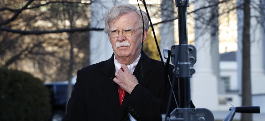 National security adviser John Bolton straightens his tie before an interview, Tuesday, March 5, 2019, at the White House in Washington.
