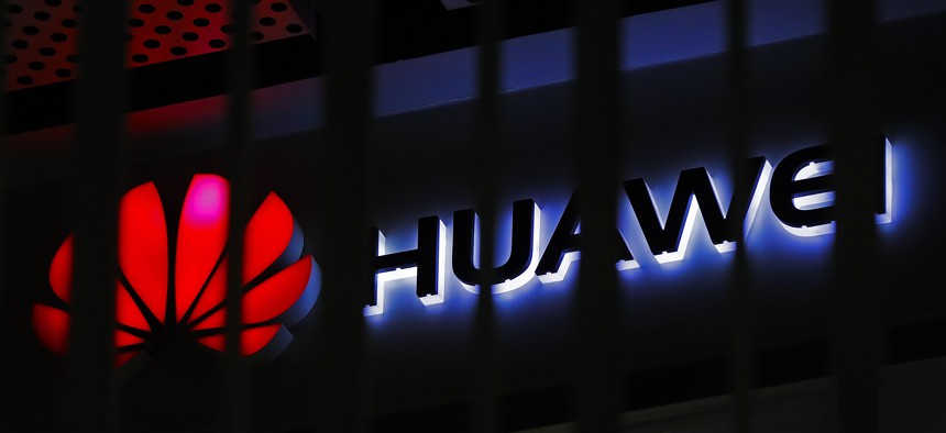 In this March 8, 2019, file photo, A logo of Huawei retail shop is seen through a handrail inside a commercial office building in Beijing. 