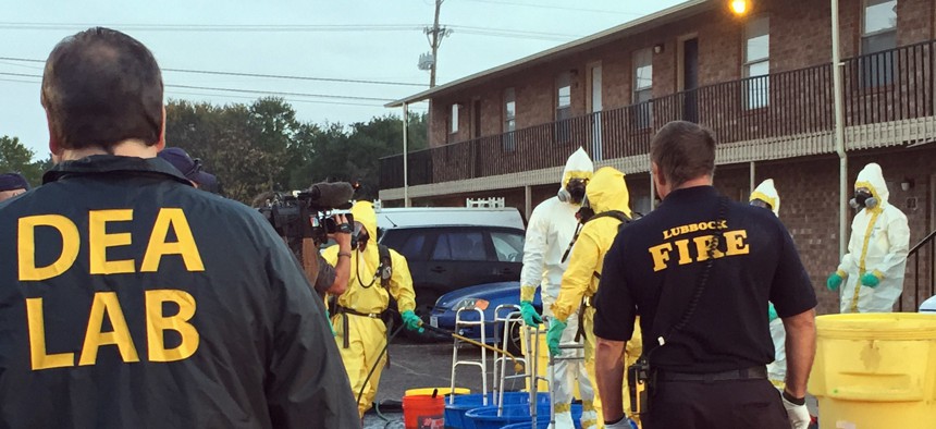 In this Oct. 27, 2016 photo, Fire Department personnel help members of the DEA Hazardous Materials/Clandestine Laboratory Enforcement Team with a decontamination procedure in Lubbock, Texas.