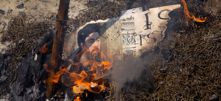 Shiite Muslims burn an effigy of the leader of the Islamic State group, Abu Bakr al-Baghdadi during a protest in New Delhi, India, Friday, June 9, 2017. 