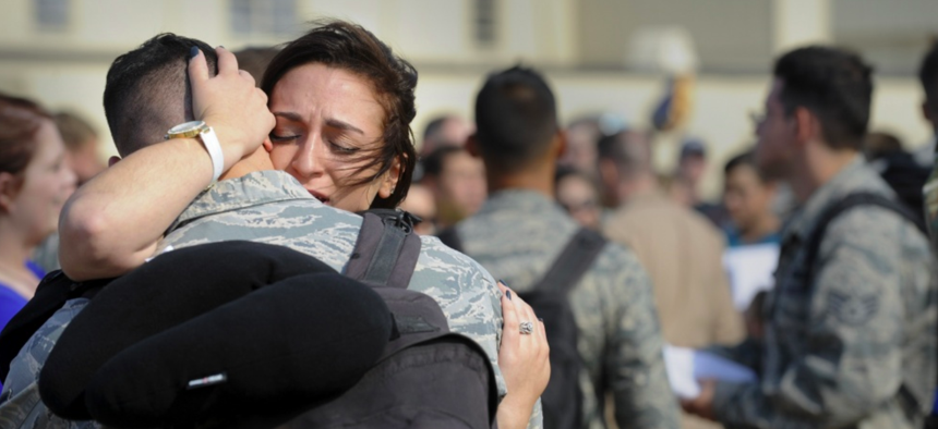 A woman hugs her husband on the tarmac at Minot Air Force Base, N.D, Sept. 11, 2017.