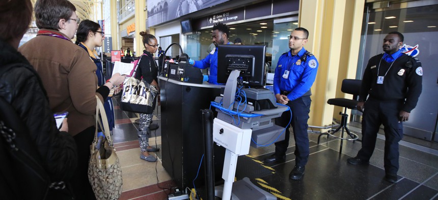 Transportation Security Administration (TSA) officers check and watch airline passengers at Reagan National Airport in Washington, Thursday, Dec. 27, 2018.