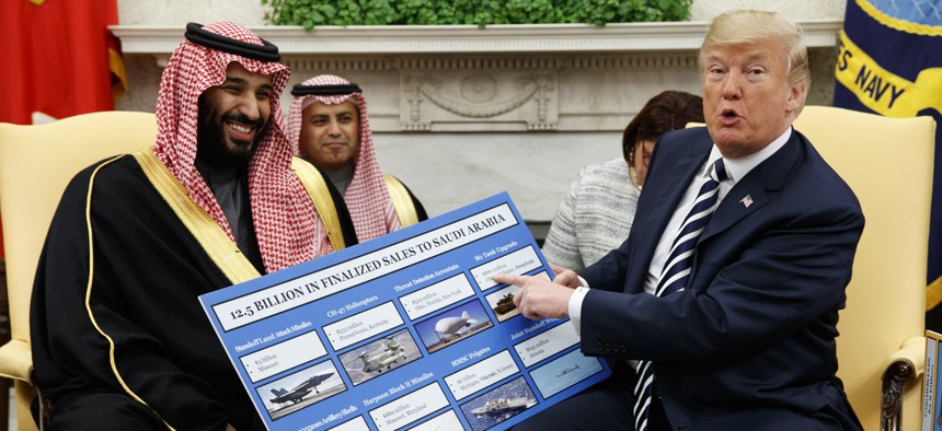 President Donald Trump shows a chart highlighting arms sales to Saudi Arabia during a meeting with Saudi Crown Prince Mohammed bin Salman in the Oval Office of the White House in Washington on March 20, 2018. 