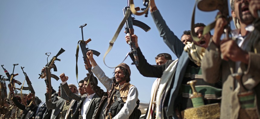 In this Dec. 13, 2018, file photo, tribesmen loyal to Houthi rebels hold up their weapons as they attend a gathering to show their support for the ongoing peace talks in Sanaa, Yemen. 