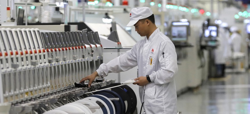 A Huawei employee works on a mobile phone production line during a media tour in Huawei factory in Dongguan, China's Guangdong province on March 6, 2019.