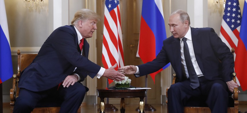 U.S. President Donald Trump, left, and Russian President Vladimir Putin shake hand at the beginning of a meeting at the Presidential Palace in Helsinki, Finland, Monday, July 16, 2018. 