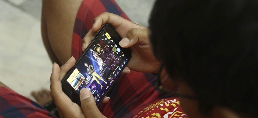 An Indian boy plays an online game PUBG on his mobile phone in Hyderabad, India, Friday, April 5, 2019.