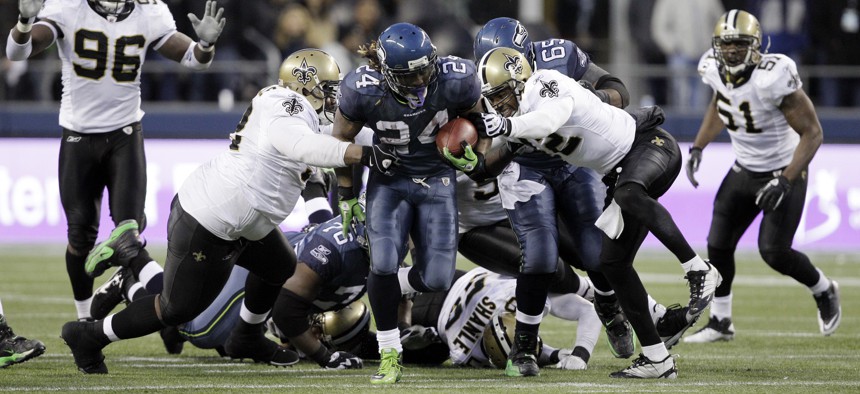Seattle Seahawks' Marshawn Lynch (24) breaks away from a tackle by the New Orleans Saints defenders to score a touchdown on Jan. 8, 2011, in Seattle.