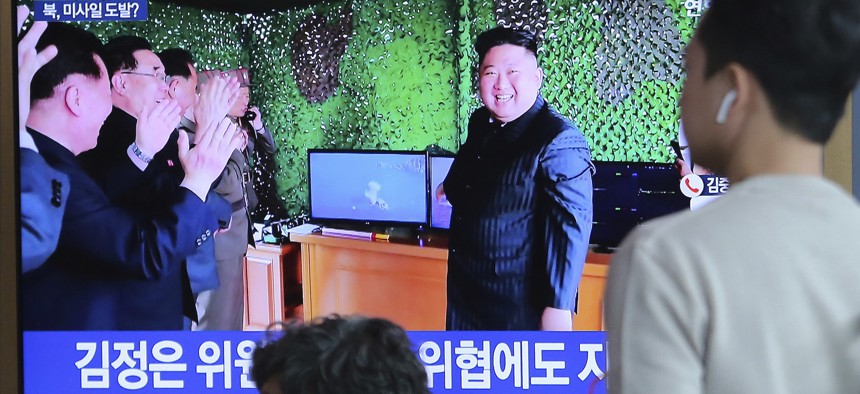 On May 5, 2019, people at a Seoul railway station watch a TV showing a photo of North Korean leader Kim Jong Un after North Korea's missile launch. 