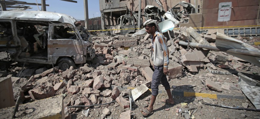 In this Feb. 4, 2018, file photo, a man inspects rubble after a Saudi-led coalition airstrike in Sanaa, Yemen.