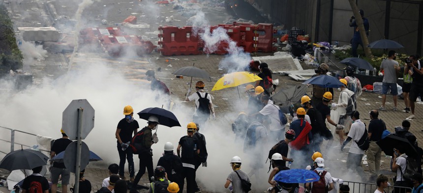 In this June 12, 2019, file photo, riot police fire tear gas toward protesters outside the Legislative Council in Hong Kong.