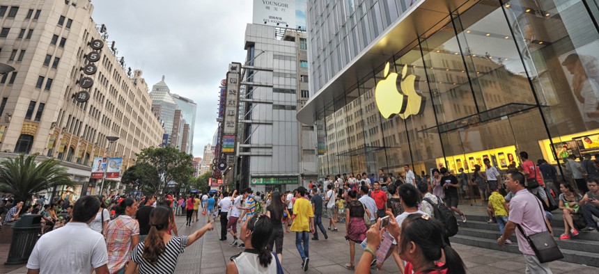 In a 2013 photo, people walk in front of the Apple store on Nanjing Road in Shanghai, China.
