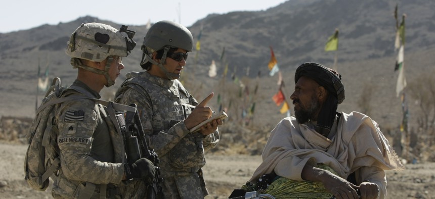 US Army Sgt. Skyler Rosenberry of Pennsylvania, left, and an Afghan interpreter, center, speak to an Afghan man during a foot patrol in Afghanistan's Kandahar province in 2010. 