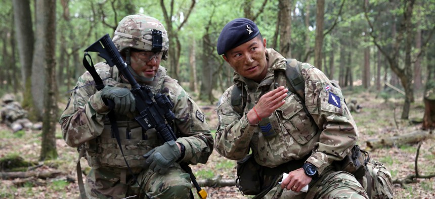 British Army Sgt. Thapa Kumar instructs U.S. Army Staff Sgt. Jeffery Lamb during a joint tactical patrol during exercise Stoney Run in the Sennelager Training Area, Germany, April 24, 2018.
