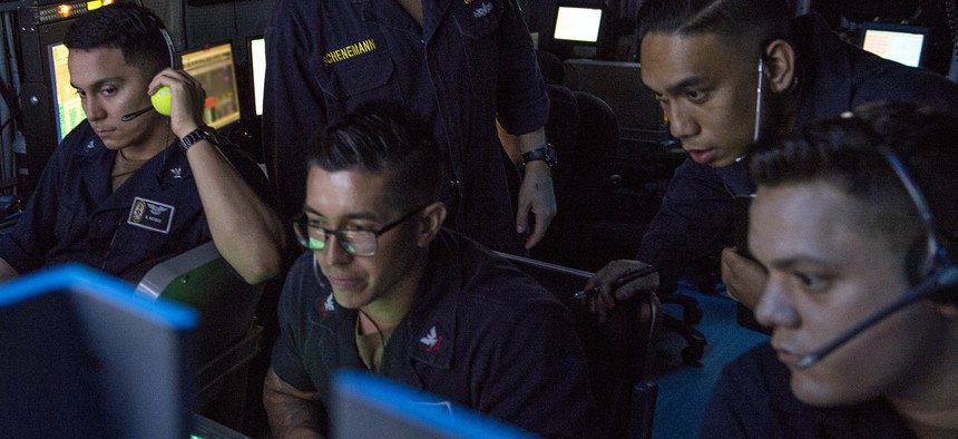 GULF OF ADEN (July 2, 2019) Sailors assigned to amphibious assault ship USS Boxer (LHD 4) observe flight operations on the display of an OD-220 radar from inside the amphibious air traffic control center.
